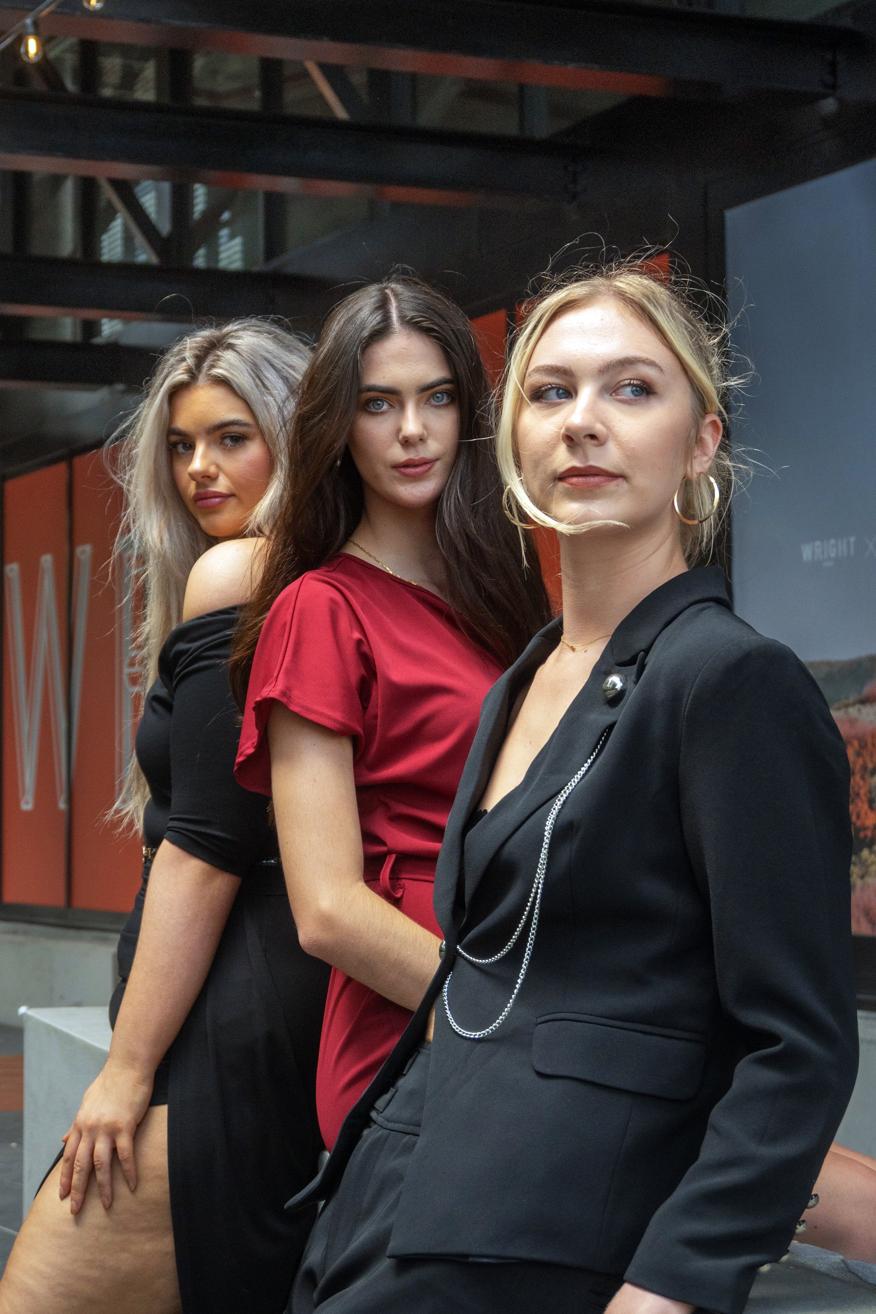 Three women posing together in an urban setting